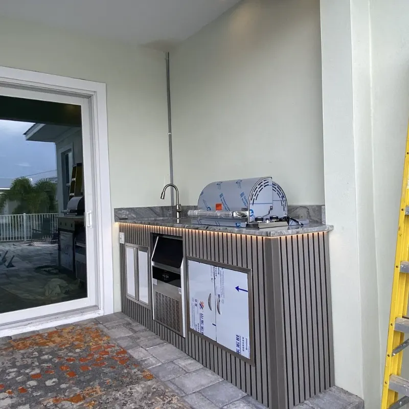 Outdoor kitchen build with grill, sink and stone countertop
