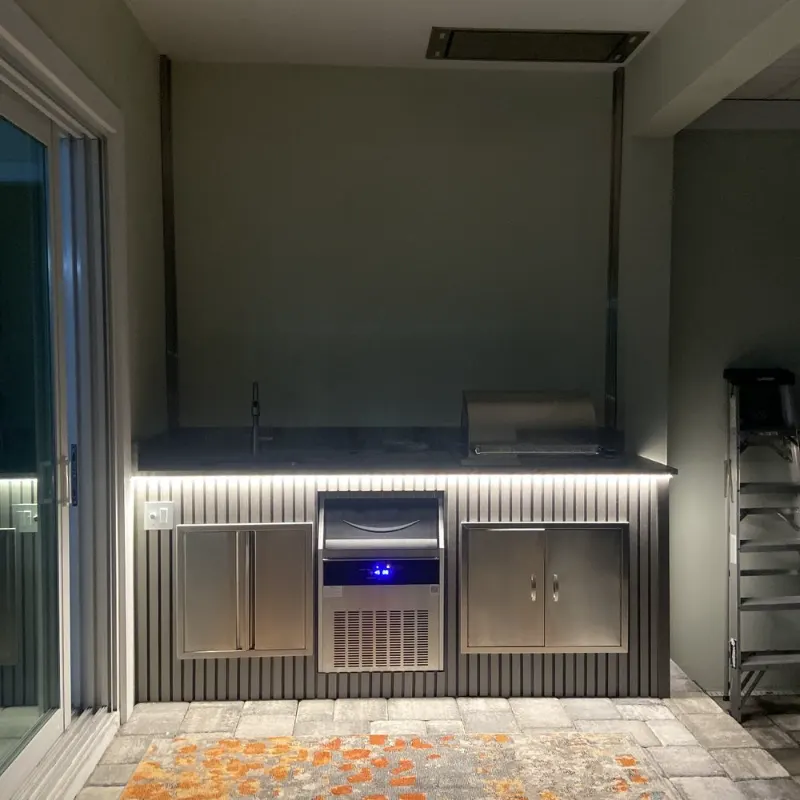 Completed outdoor kitchen with under-counter lighting at night