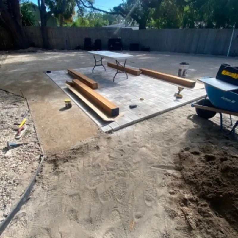 Paver patio installation in progress in a Lakeland backyard
